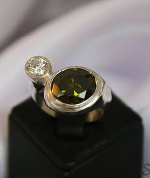 Silver synthetic perdiot ring offset with c/z